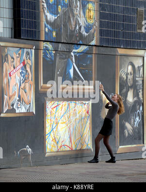 I turisti play e prendere selfies sulla parte anteriore della strada murales che decorano l'edificio om Argyle Street Glasgow Foto Stock