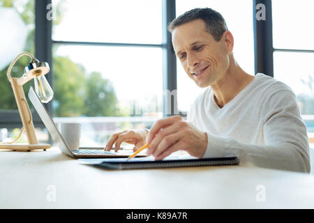 Felice imprenditore positivo confrontando i dati statistici Foto Stock