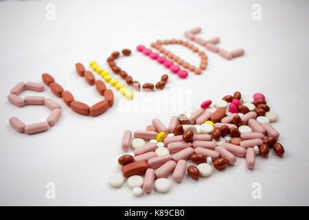 Un suicidio la parola, la scrittura sullo sfondo bianco sulle pillole con copia spazio. Foto Stock