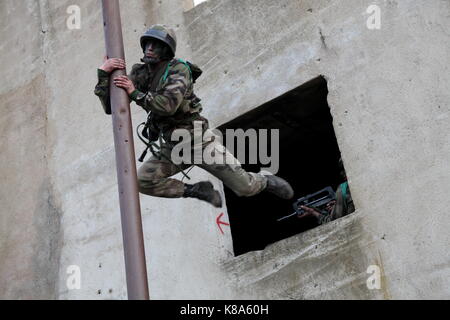 Un legionario dal 2REP (seconda estera reggimento Paratroop) salta da una finestra aperta durante un combattimento urbano esercizio in Fraseli, Corsica su Marzo 24 Foto Stock