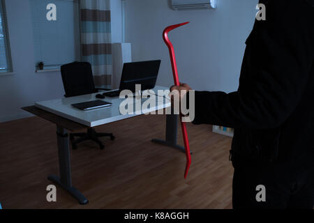 Close-up del ladro Holding palanchino in Office Foto Stock