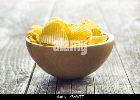 Croccanti patatine nella ciotola di legno. Salate potato chips. Foto Stock