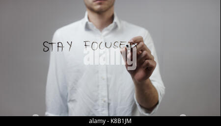 Rimanere concentrati , l' uomo la scrittura su vetro Foto Stock