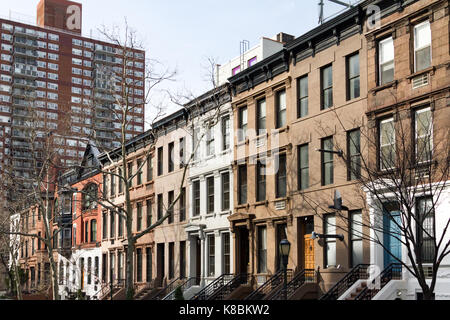 Fila di storici edifici di arenaria con colorati porte lungo un blocco a Manhattan, New York City nyc Foto Stock