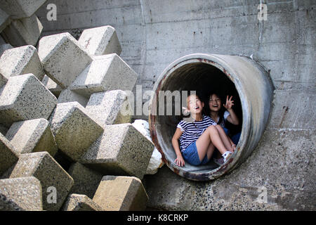 Ragazze sbirciando attraverso il foro Foto Stock