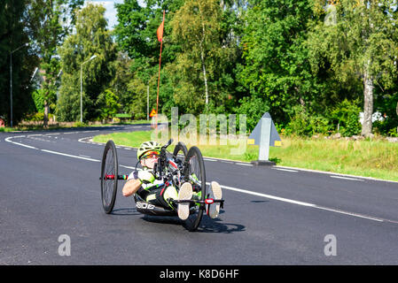 Emmaboda, Svezia - 28 agosto 2017: vita reale documentario di persona sconosciuta la formazione su una mano distesa powered racing triciclo sulla pubblica via. Foto Stock