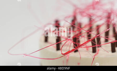 La torta di panna con tre strati su una piastra. La torta di panna con tre strati, decorata con cioccolato sbriciolati e paglia di cioccolato Foto Stock