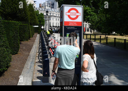 Un paio di guardare la mappa accanto al Santander bike park a Hyde Park Londra Foto Stock