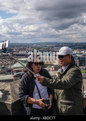 I turisti di prendere foto con auto-stick Sui merli del castello di Edimburgo, città vecchia, Edimburgo, Scozia Foto Stock