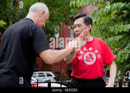 Noi Accademia di Wushu gli studenti di eseguire un maestro di kung fu in un evento pubblico - Washington DC, Stati Uniti d'America Foto Stock