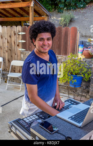 Uomo ispanico, disc jockey, deejay, dj, la riproduzione di musica, intrattenimento musicale, party in piscina, Castro Valley, contea di Alameda, California Foto Stock