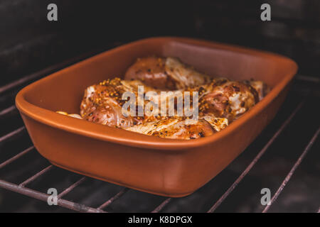 Crudo marinato le cosce di pollo sono in forno, tonificazione retrò. Foto Stock