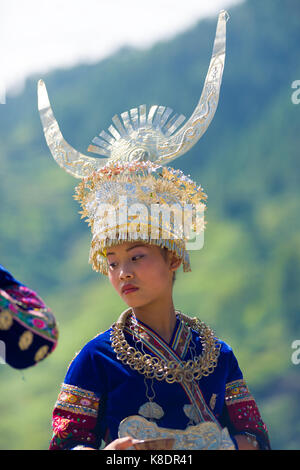 Xijiang, Cina - 15 Settembre 2007: una minoranza etnica Miao donna in festa tradizionale costume e grandi di acconciatura di argento nella parte anteriore del mountain bac Foto Stock