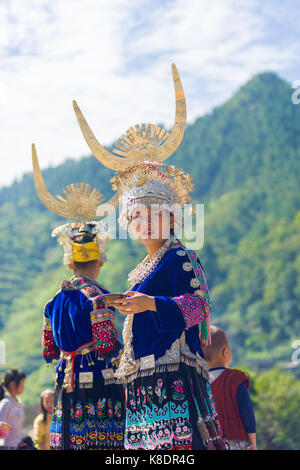 Xijiang, Cina - 15 Settembre 2007: una minoranza etnica Miao donna nella tradizionale festa abiti e acconciatura di argento in piedi nella parte anteriore della natura ba Foto Stock
