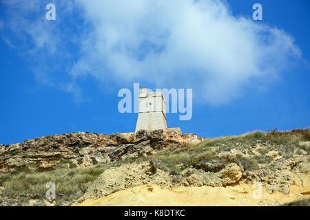 Vista di Ghajn Tuffieha torre di avvistamento che domina la costa, Golden Bay, Malta, l'Europa. Foto Stock