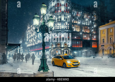 I popoli e le auto in strada vicino a TSUM shopping center a Mosca durante la tempesta di neve. Foto Stock