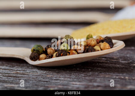 Le spezie in polvere su palette in legno nero lo sfondo della tabella Foto Stock