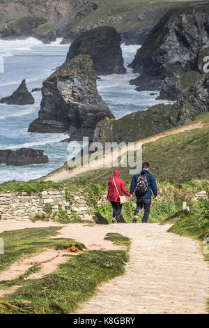 Tregurrian - un giovane camminando mano nella mano lungo la costa sud occidentale percorso in corrispondenza di Bedruthan Steps sulla North Cornwall coast. Foto Stock