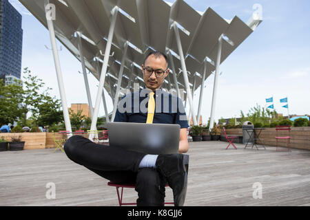 Imprenditore utilizzando laptop fuori dall'hotel, New York, Stati Uniti d'America Foto Stock