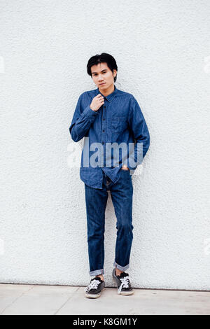 Ritratto di giovane uomo all'aperto, i jeans e maglietta denim Foto Stock