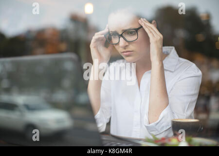 Donna che utilizza computer portatile alla ricerca ha sottolineato Foto Stock