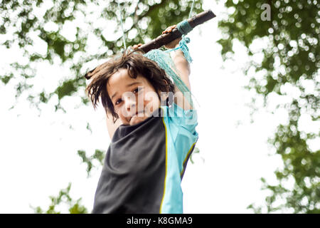 Ragazzo giovane basculante in home-fatta oscillare nella struttura ad albero a basso angolo di visione Foto Stock