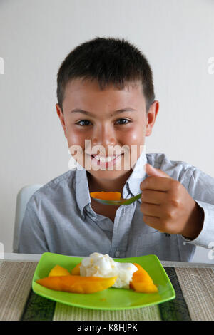 Ragazzo che mangia riso appiccicoso con mango. thailandia. Foto Stock