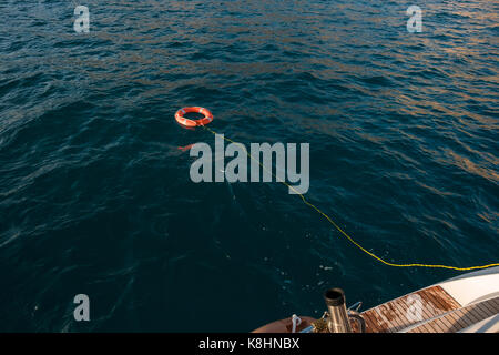 Angolo di alta vista di anello gonfiabile attaccato con corda sulla barca in mare Foto Stock