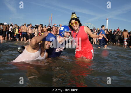 Festaioli tuffarsi, nuotare e party in Atlantico come parte dell'annuale Coney Island Polar Bear Club del primo giorno del nuovo anno le celebrazioni del 1 gennaio 2012. Foto Stock