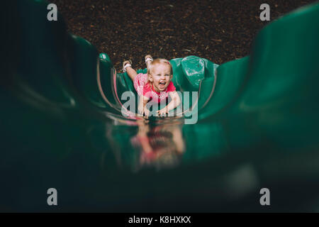 Angolo alto ritratto di happy Baby girl giocando sulla slitta al parco giochi Foto Stock