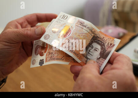 Un uomo nella foto tenendo un nuovo dieci pound nota nella sua casa a Chichester, west sussex, Regno Unito. Foto Stock