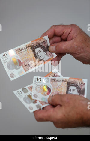 Un uomo nella foto tenendo un nuovo dieci pound nota nella sua casa a Chichester, west sussex, Regno Unito. Foto Stock
