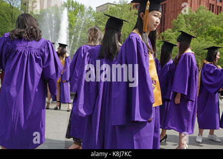 New York, NY, Stati Uniti d'America - 16 Maggio 2017: la New York University gli studenti di cappucci e abiti, riuniti a Washington Square Park per festeggiare la laurea Foto Stock