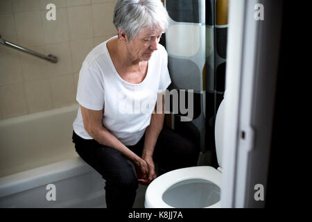 Il pensionamento donna cadde in una toilette Foto Stock