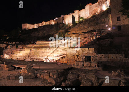 Vista notturna sul teatro romano Alcazaba e collina con castello (castillo de Gibralfaro) a Malaga, Spagna Foto Stock