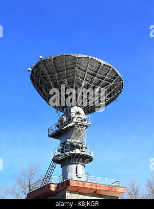 Antenna parabolica per la comunicazione satellitare con un materiale metallico catadiottro sul tetto dell'edificio Foto Stock