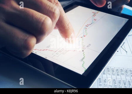 Stock broker holding tablet con candela stick grafico. stock trading online. Foto Stock