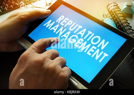 La gestione della reputazione su uno schermo del tablet. Foto Stock