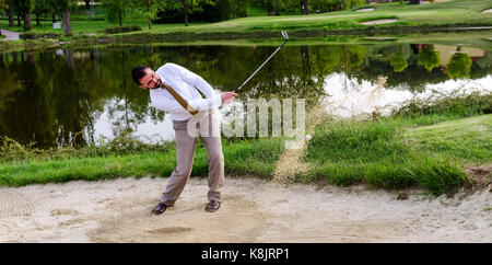 Imprenditore golfista nella trappola di sabbia Foto Stock