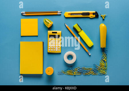 Composizione del giallo di forniture scolastiche su blu Foto Stock