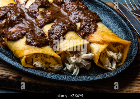 Cucina messicana. Tradizionale messicano enchiladas di pollo con cioccolato speziato salsa mole poblano. Enchiladas con salsa moole da Puebla, Messico. Foto Stock