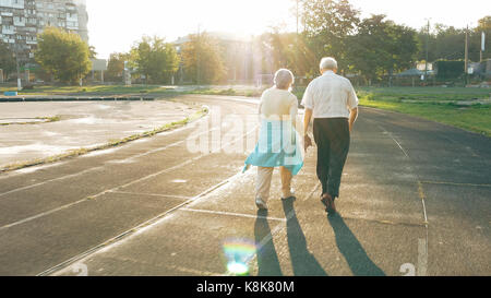 Coppia senior a piedi lungo la via di corsa Foto Stock