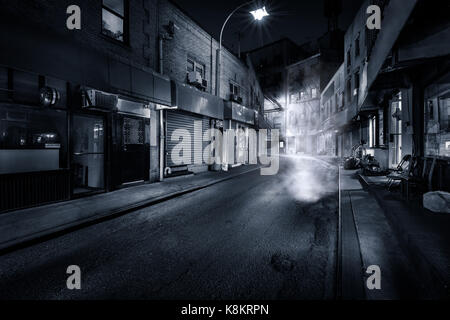 Moody visualizzazione monocromatica di Doyers Street di notte a New York Chinatown. La curvatura è diventato noto come 'la sanguinosa angolo' a causa di numerose pista tiri. Foto Stock