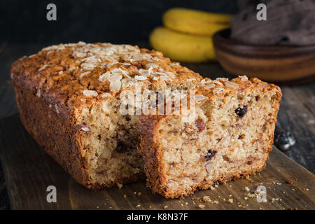 In casa pane alla banana focaccia con noci tagliate a fette sul tagliere di legno. primo piano, orizzontale Foto Stock