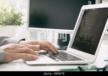 Lavoro Programmatore occupato di sviluppo software in ufficio della società. Programmatore di codice di programma di computer technology office software mani sul concetto di notebook Foto Stock