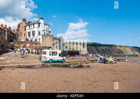 Ice Cream van parcheggiato sulla spiaggia a bassa marea a Robin Hood's Bay nel North Yorkshire. Foto Stock