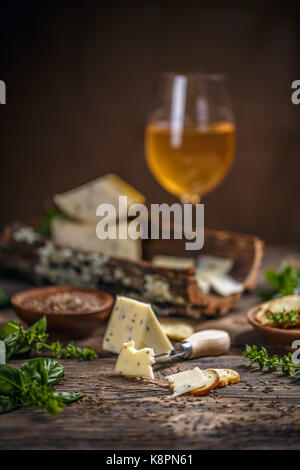 Formaggio con semi di cumino sul vecchio sfondo di legno Foto Stock