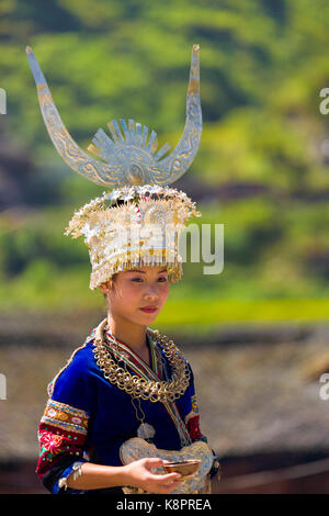 Xijiang, Cina - 15 Settembre 2007: Bella minoranza etnica Miao donna che indossa il festival tradizionale vestiti e argento di acconciatura di avvisatore acustico in attesa di c Foto Stock