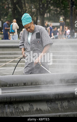 A New York City il Dipartimento parchi di Potere operaio il lavaggio della area fontana di Washington Square Park in Greenbwich Village, New York City. Foto Stock