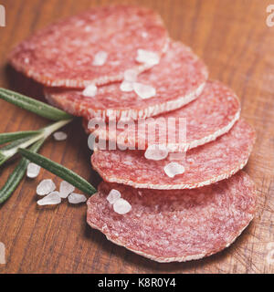 Salame le fette di salsiccia con rosmarino e sale marino Foto Stock